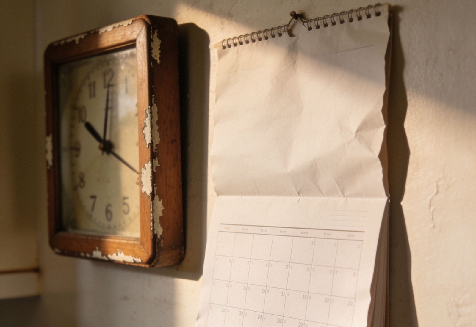 Relógio antigo e calendário numa parede de cozinha